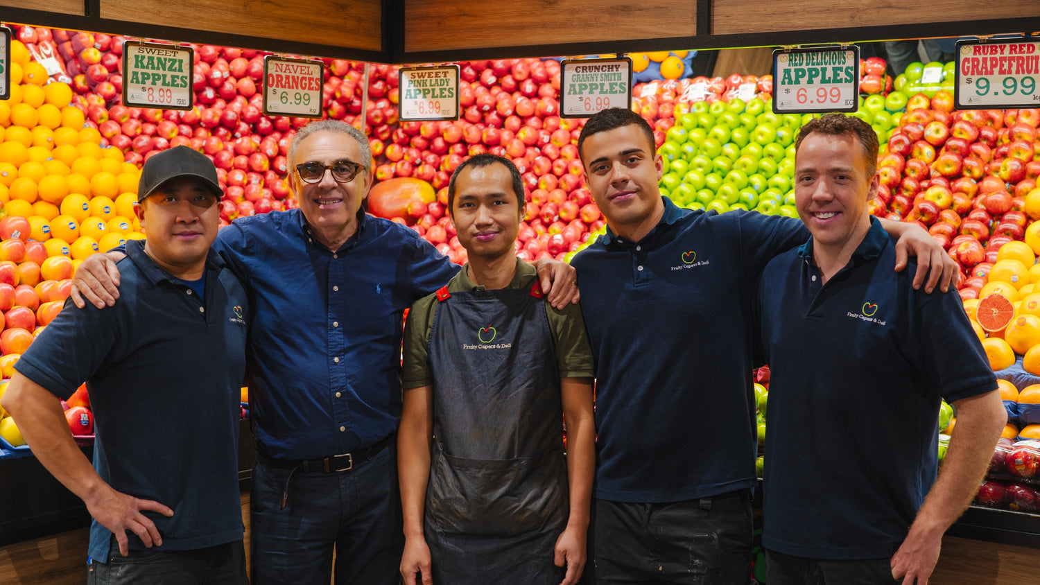 Fruity Capers & Deli team standing in front of colorful fruit displays